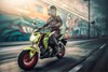 Three-quarter front angle of a person riding a motorcycle on the street.