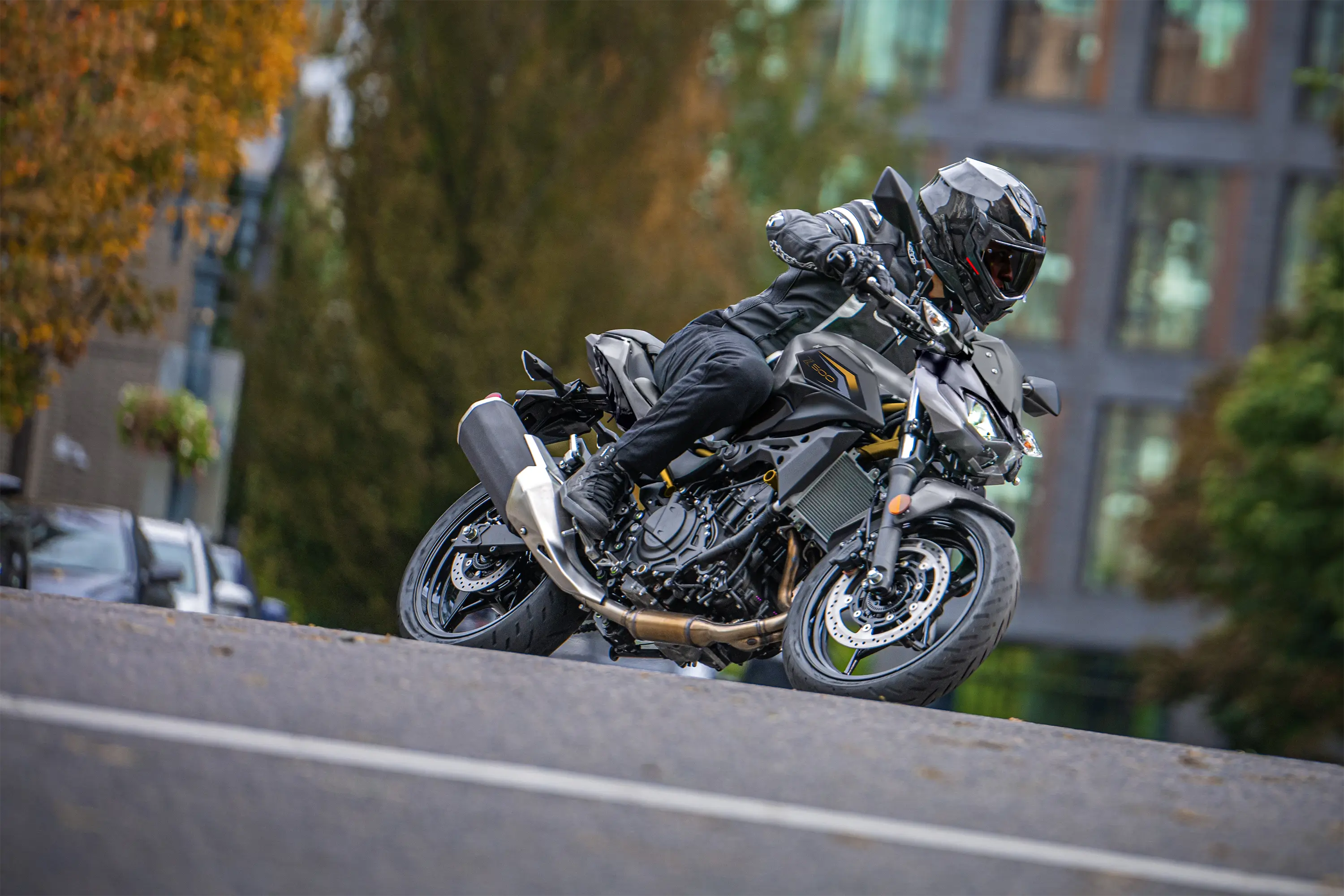 Side angle of a person riding a motorcycle on the street.