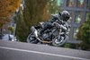 Side angle of a person riding a motorcycle on the street.