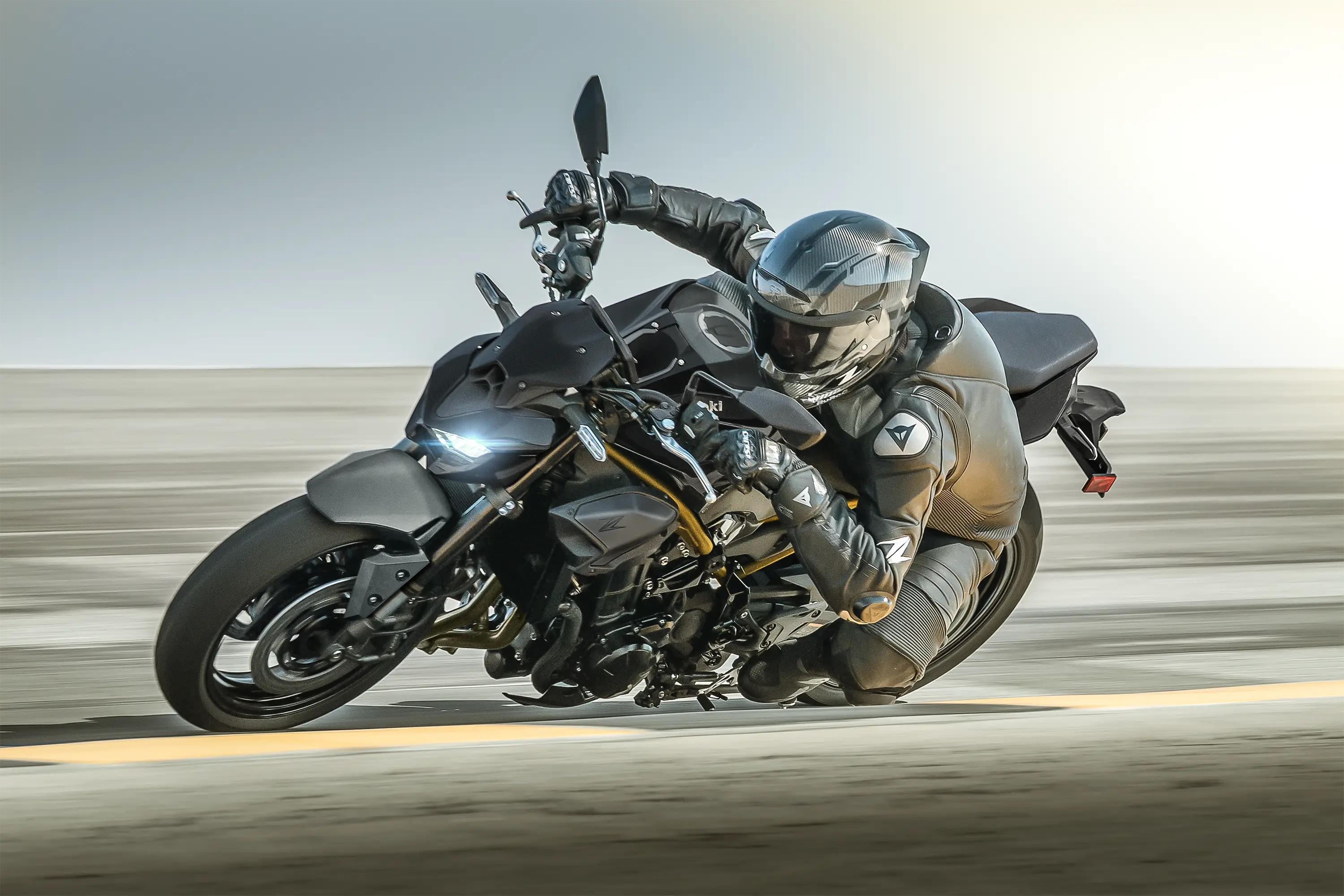 Side angle of a person aggressively turning a motorcycle on the street.