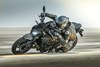 Side angle of a person aggressively turning a motorcycle on the street.