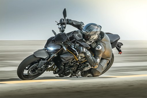Side angle of a person aggressively turning a motorcycle on the street. opens in a new window