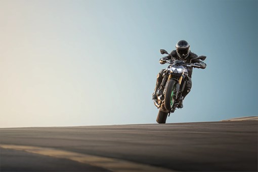 Front angle of a person riding a motorcycle on a track. opens in a new window