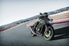 Front three-quarter angle of a person riding a motorcycle turning on a track.