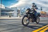 Three-quarter front angle of a person riding a motorcycle on the street.
