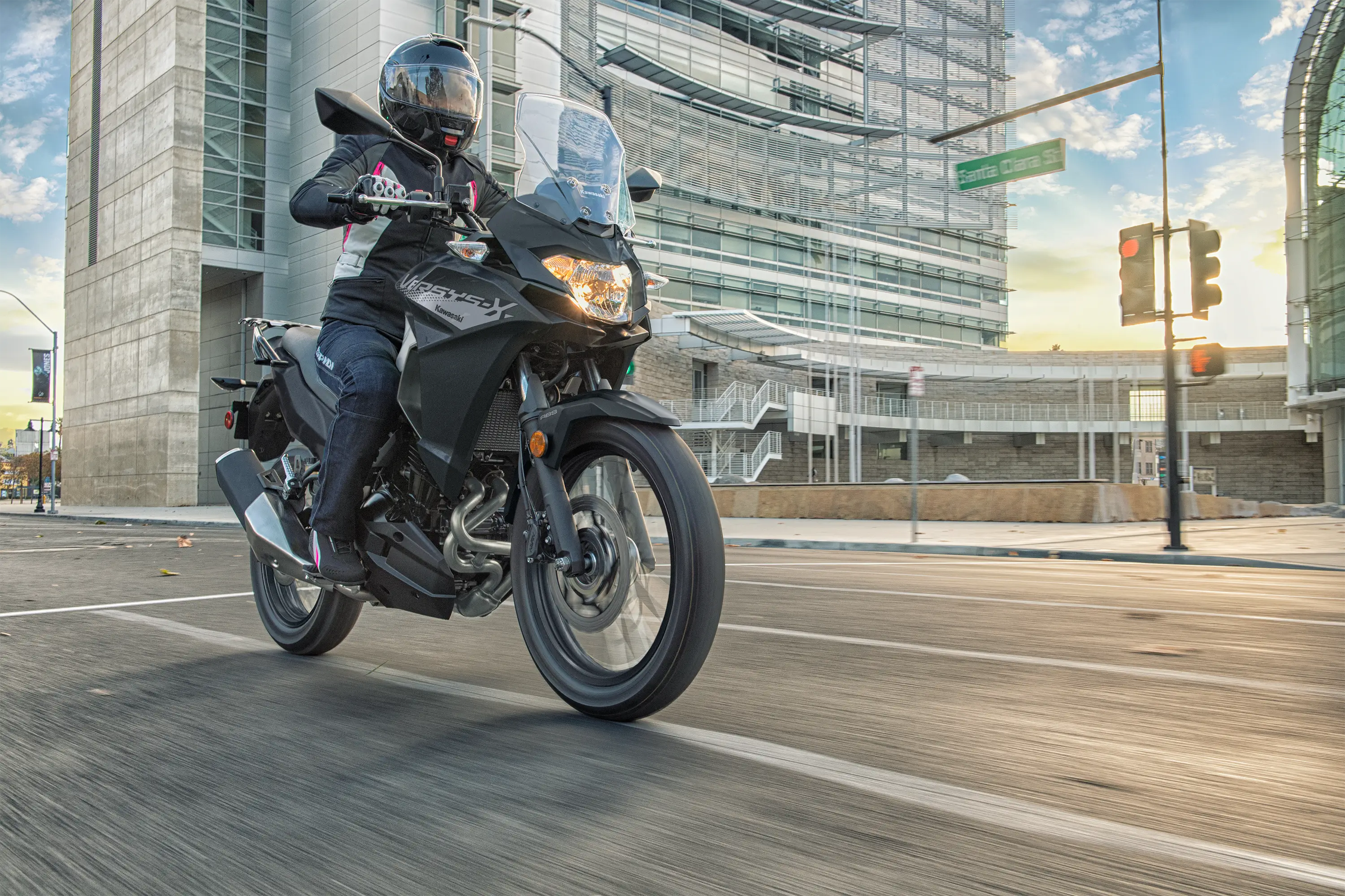 Front three-quarter angle of a person riding a motorcycle on the street.