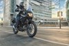 Front three-quarter angle of a person riding a motorcycle on the street.