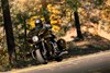 Front three-quarter angle of a person riding a motorcycle on a scenic drive.