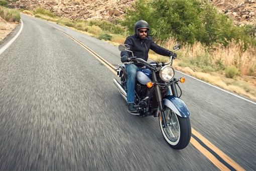 Front three-quarter angle from above of a person riding a motorcycle on a highway. opens in a new window