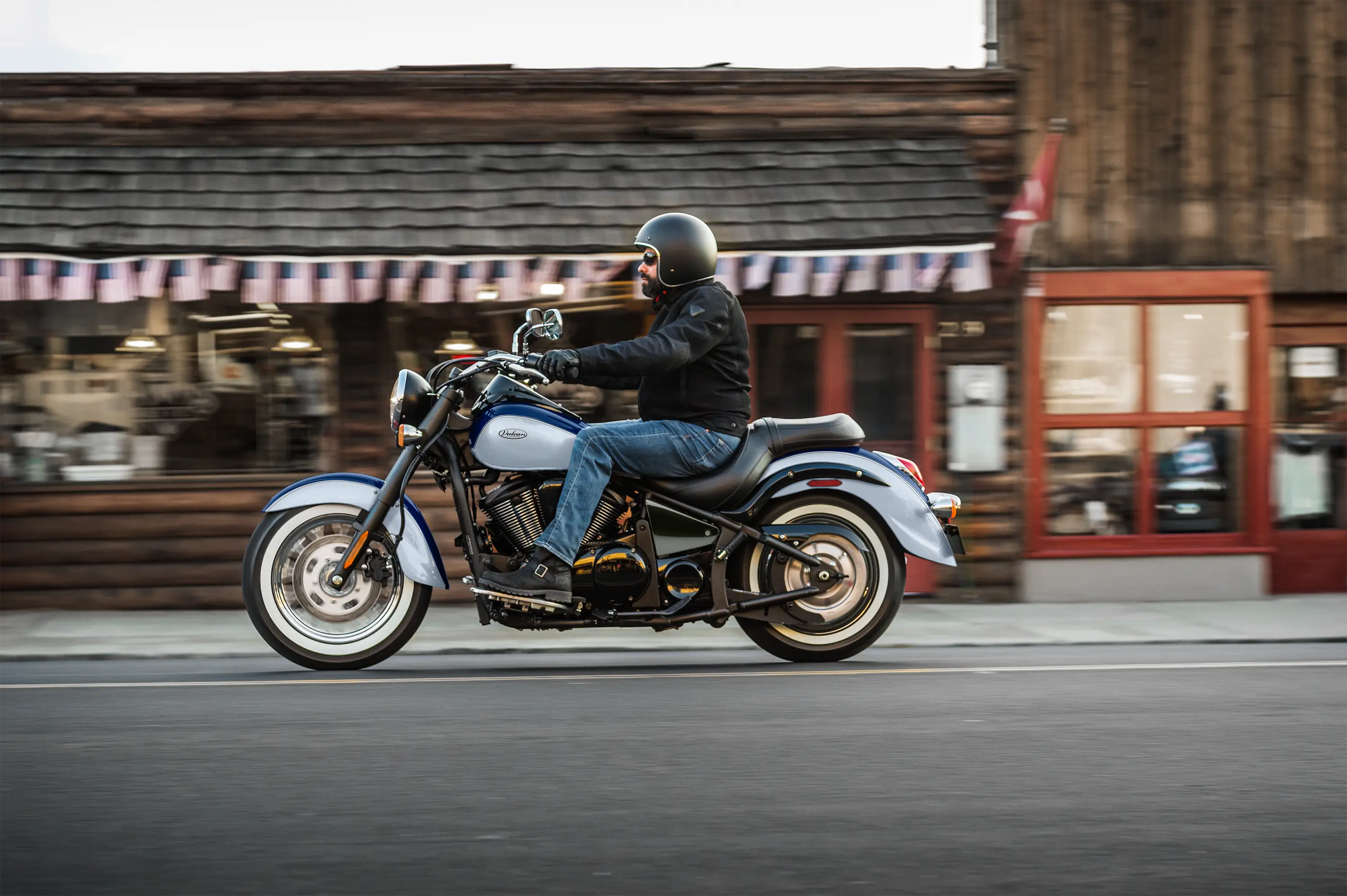 Side angle of a person riding a motorcycle on the street.