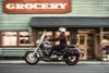 Side angle of a person riding a motorcycle on the street.