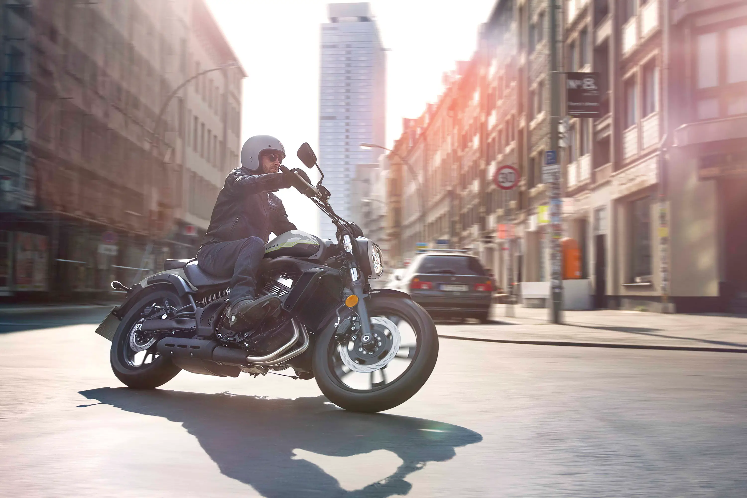 Side angle of a person riding a motorcycle downtown.