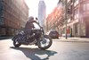 Side angle of a person riding a motorcycle downtown.