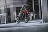 Three-quarter front angle of a person riding a motorcycle downtown.