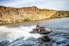 Side overhead angle of a person on a personal watercraft on the water.
