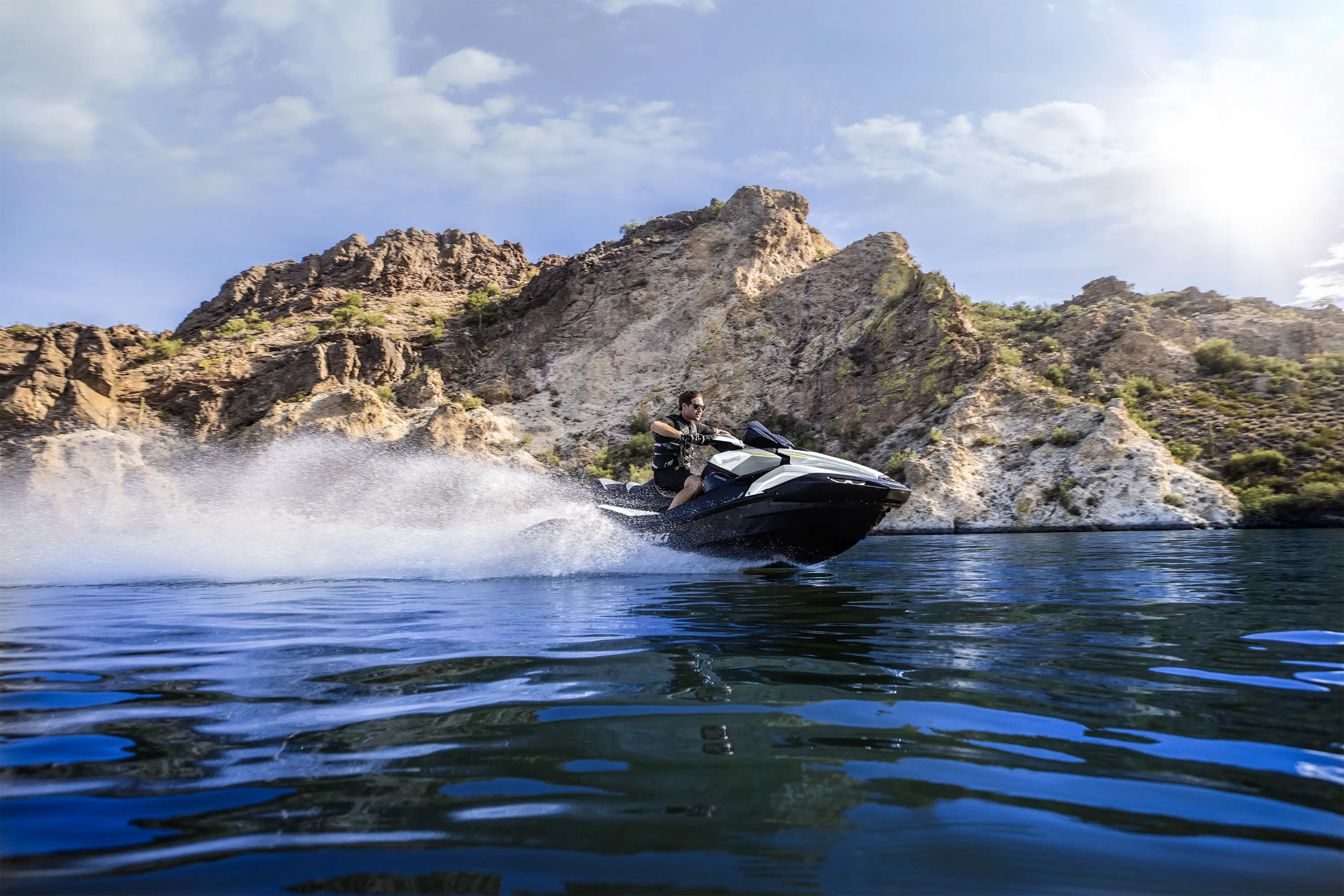 Three-quarter low front angle of a person on a personal watercraft on the water.