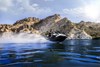 Three-quarter low front angle of a person on a personal watercraft on the water.