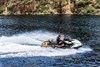 Side angle of a person on a personal watercraft on the water.