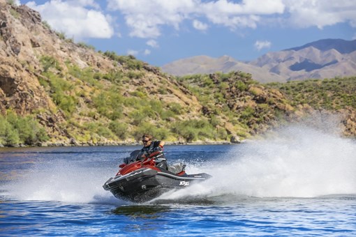 Front three-quarter angle of a person on a personal watercraft on the water. opens in a new window