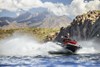 Three-quarter front angle of a person on a personal watercraft on the water.