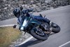 Three-quarter front angle of a person riding a motorcycle on a highway.
