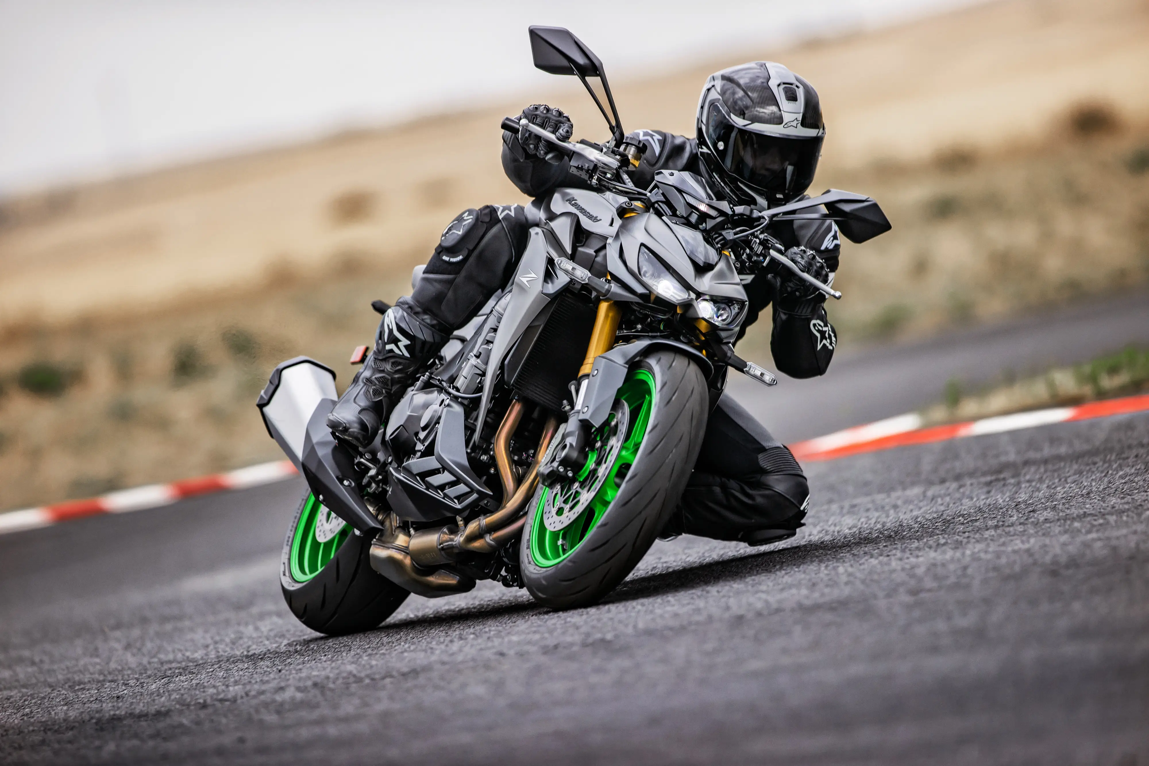 Three-quarter front angle of a person riding a motorcycle through a corner on a track.