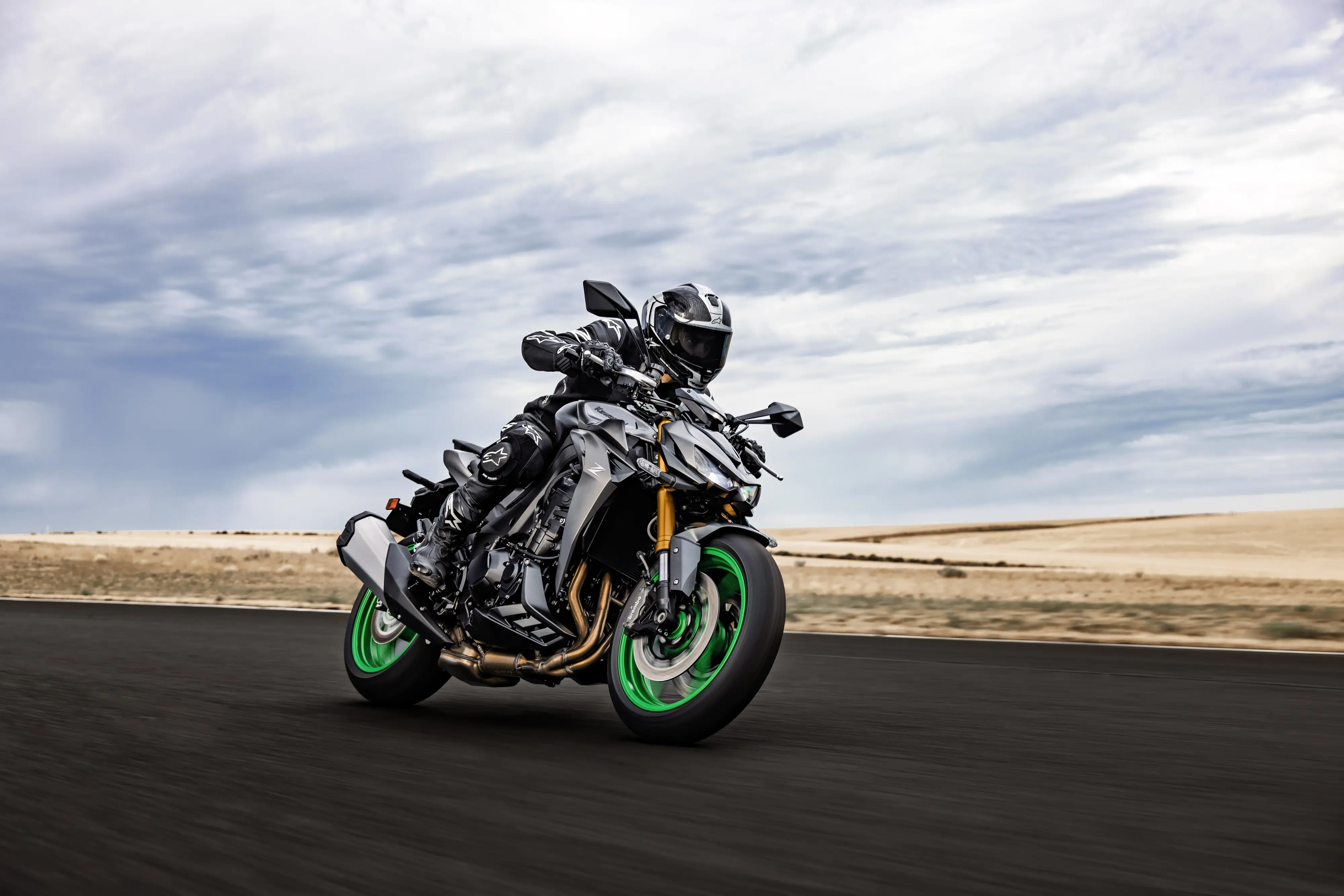 Three-quarter front angle of a person riding a motorcycle on a track.
