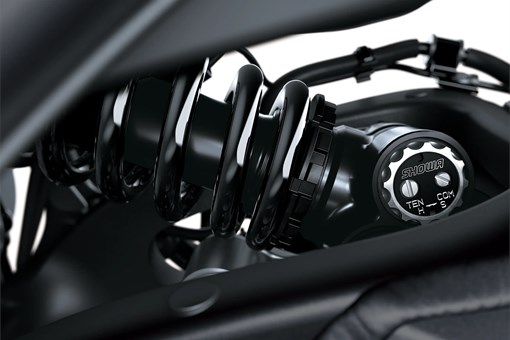 Close-up of the shock of a motorcycle staged in a white studio background. opens in a new window