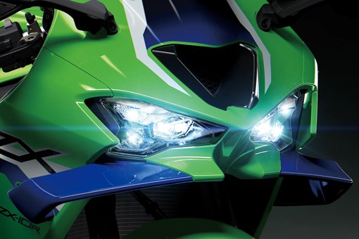 Close-up of the front-end of a motorcycle staged in a black studio background. opens in a new window