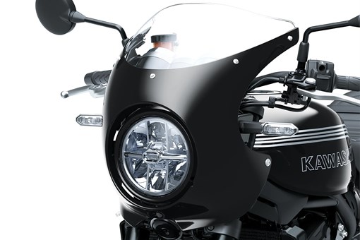 Close-up of the headlight of a motorcycle staged in a white studio background. opens in a new window