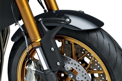 Close-up of the front tire of a black motorcycle staged in a white studio background. opens in a new window