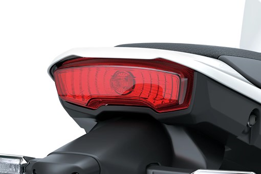 Closeup on taillight of a motorcycle staged in a white studio background. opens in a new window