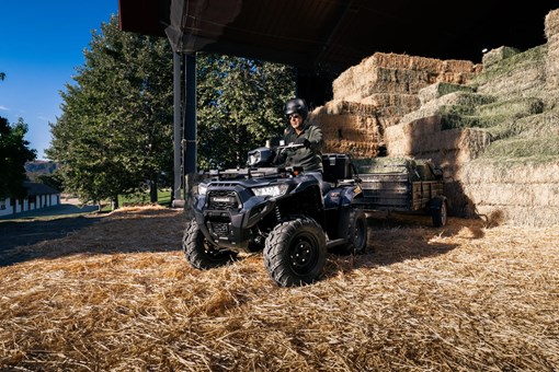 Three-quarter front angle of a person towing a trailer with an ATV. opens in a new window