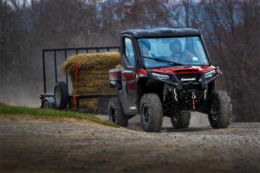Front angle of a side x side towing a trailer on a gravel road. opens in a new window