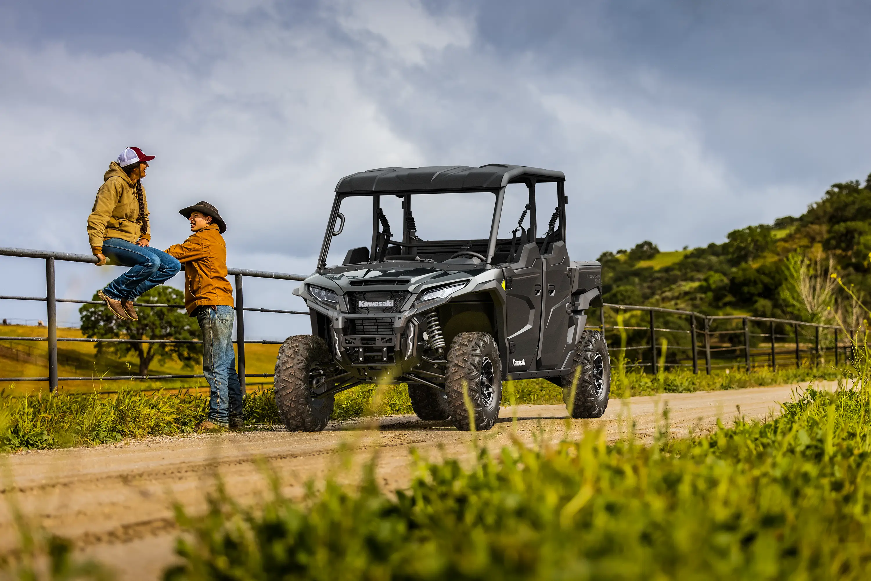 Three-quarter front angle of a side x side parked on a farm road.