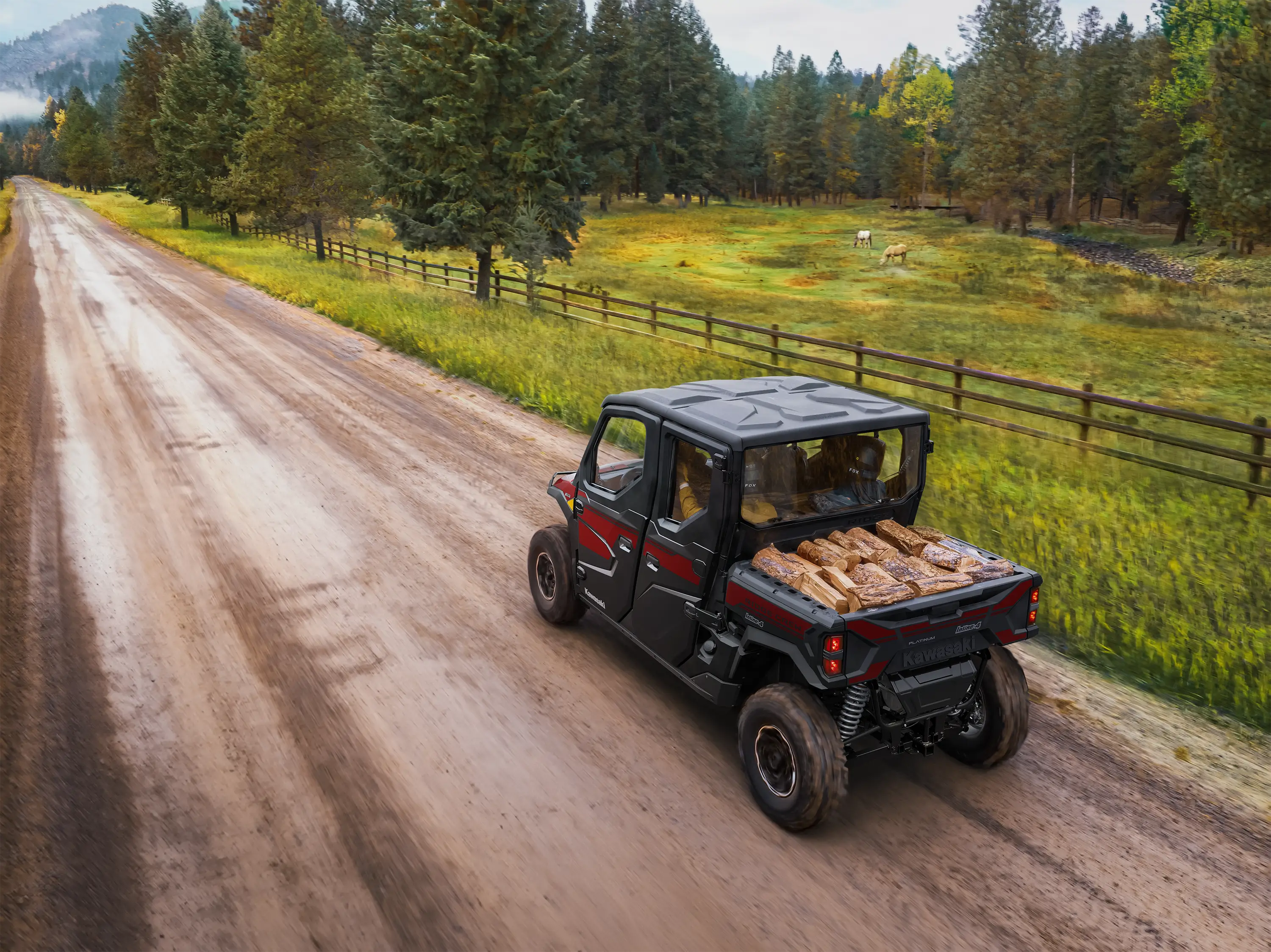 Rear aerial view of person driving a side x side on a dirt road.