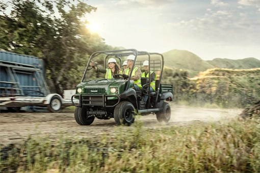 Three-quarter front angle of four people driving a side x side off-road. opens in a new window