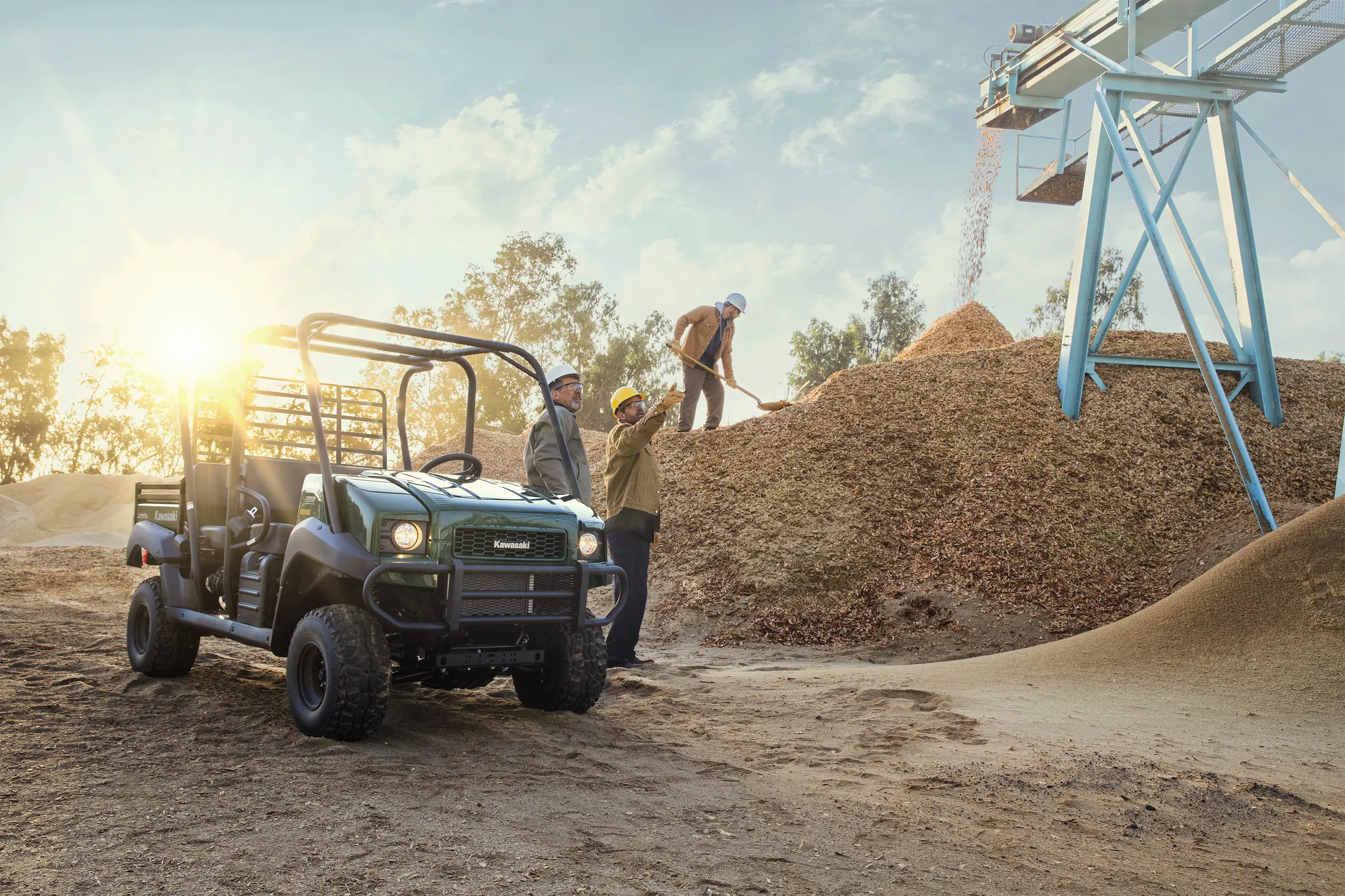 Three-quarter front angle of a green side x side parked off-road.