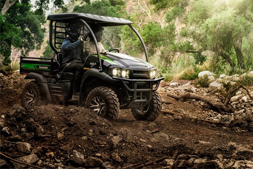 Two people riding in a side x side through rocky, uneven off-road terrain. opens in a new window
