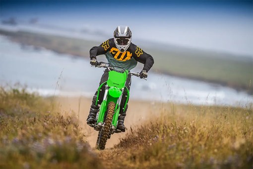 Oncoming view of a person riding an off-road dirt bike on a fast trail. opens in a new window