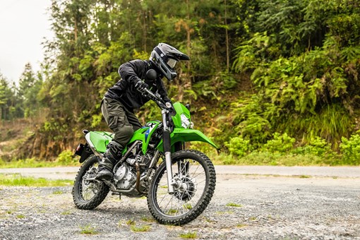 Three-quarter front angle of a person riding a motorcycle off-road. opens in a new window