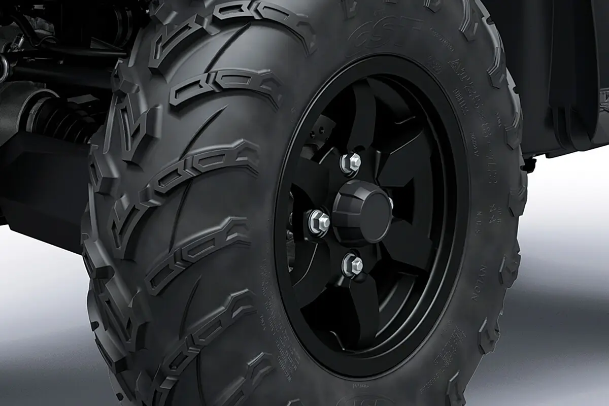 Detail view of a wheel and tire of a utility ATV in a white studio background.