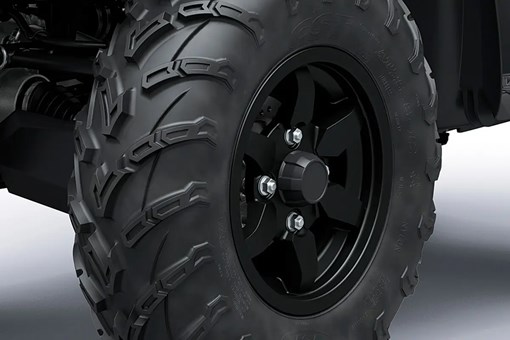 Detail view of a wheel and tire of a utility ATV in a white studio background. opens in a new window