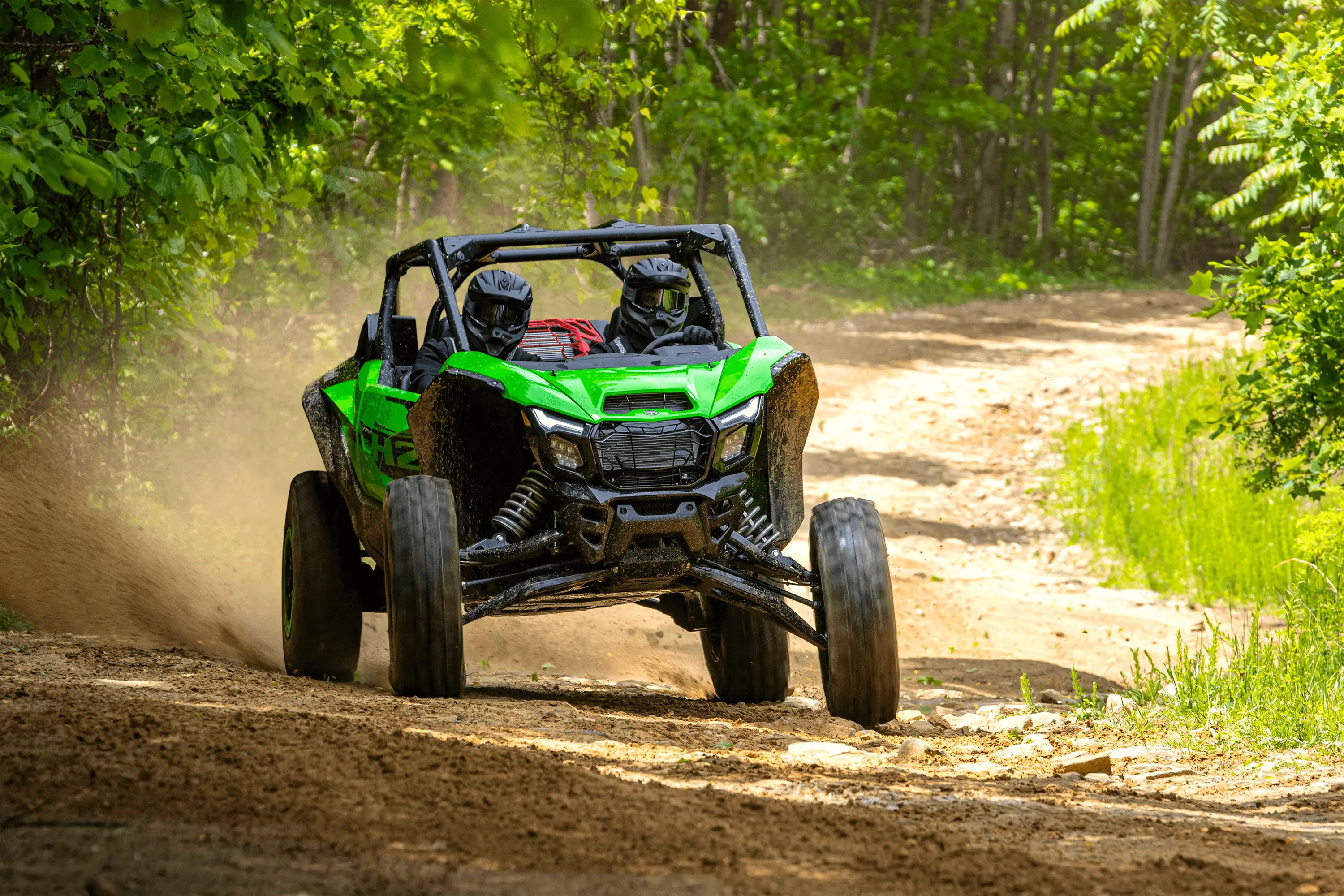 Three-quarter front angle of a person driving a side x side off-road.