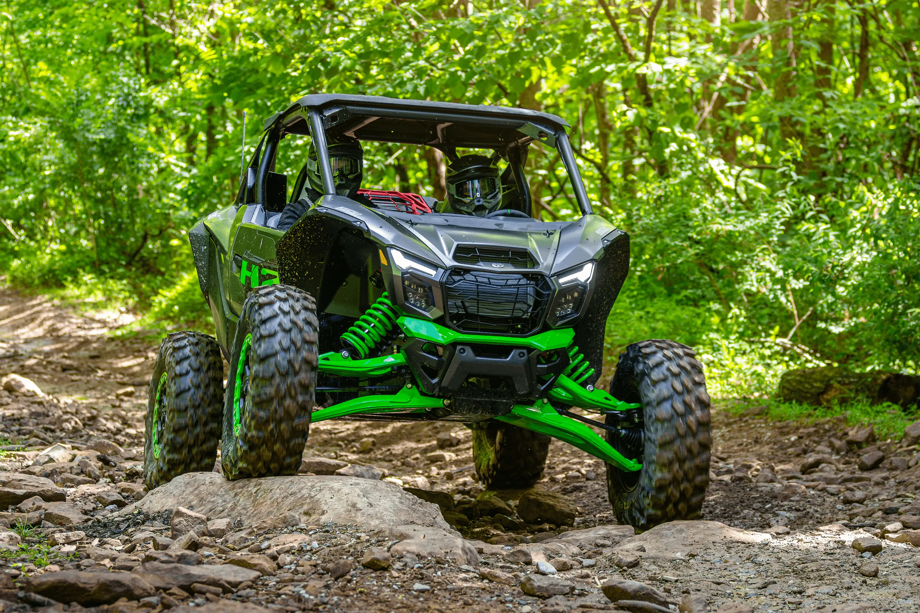 Three-quarter front angle of a side x side going over rocks.