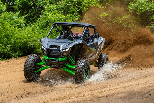Three-quarter front angle of a person driving a side x side through water. opens in a new window