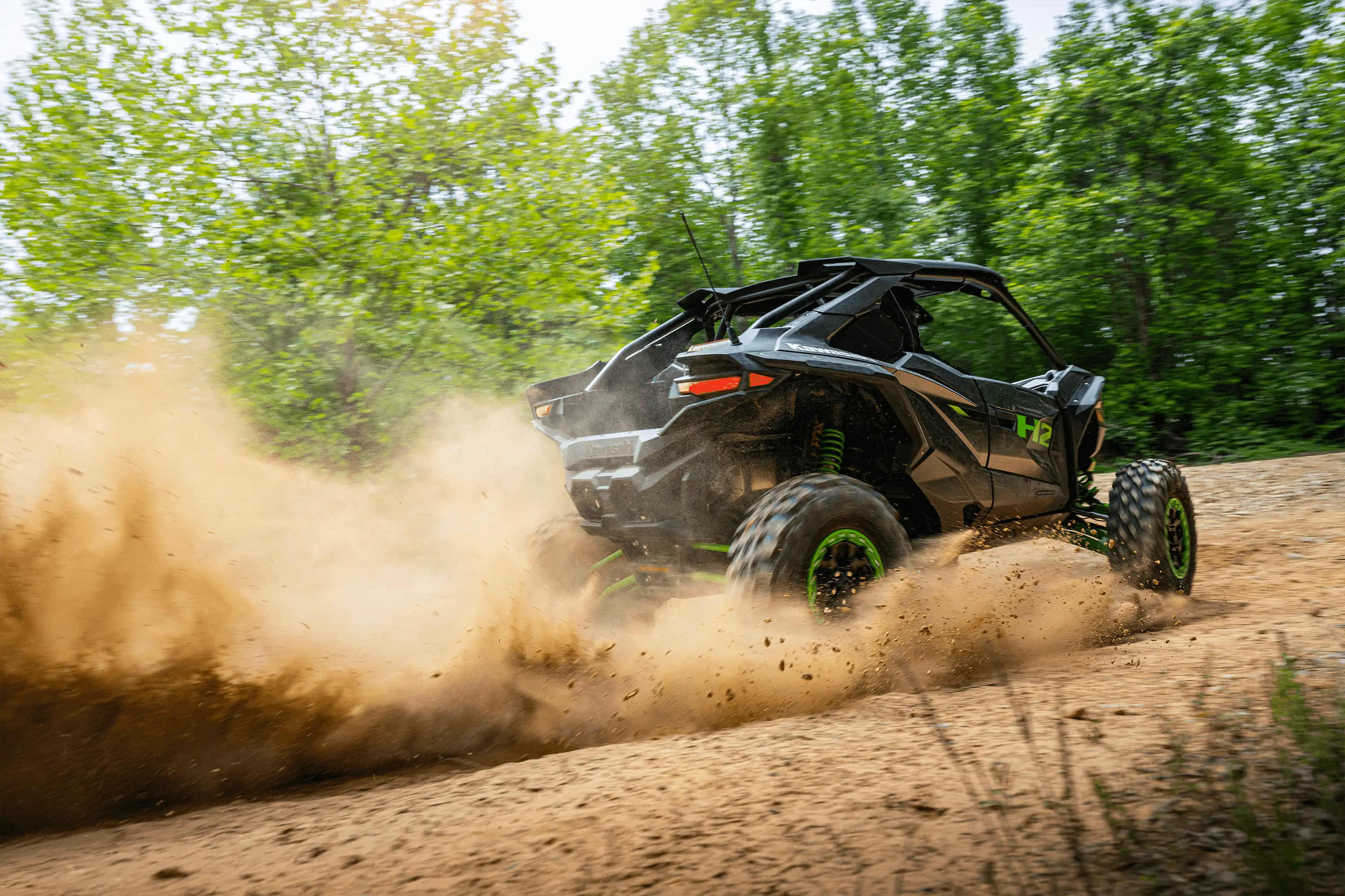 Three-quarter rear angle of a person driving a side x side off-road.