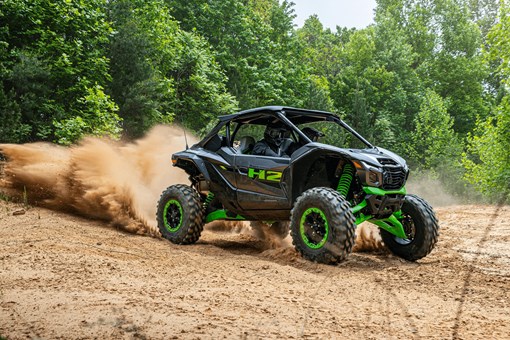 Side angle of a person driving a side x side off-road. opens in a new window