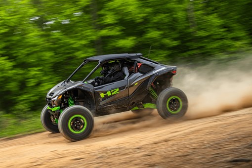 Side angle of a person driving a side x side downhill off-road. opens in a new window