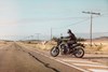 Profile angle of person riding a motorcycle onto a highway,